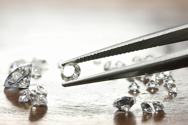 istock brilliant cut diamond held by tweezers 1627048920