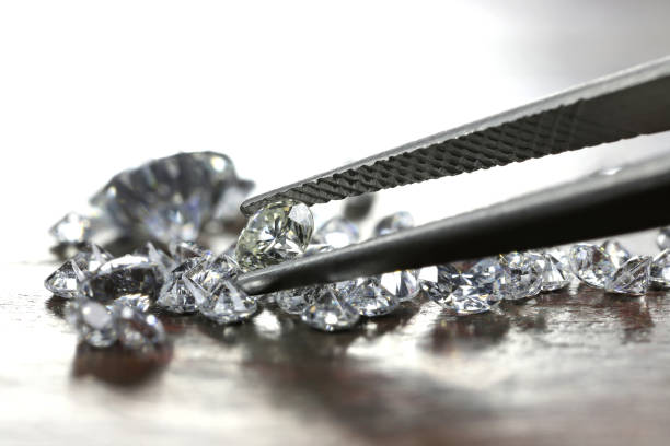istock brilliant cut diamond held by tweezers 1627049462