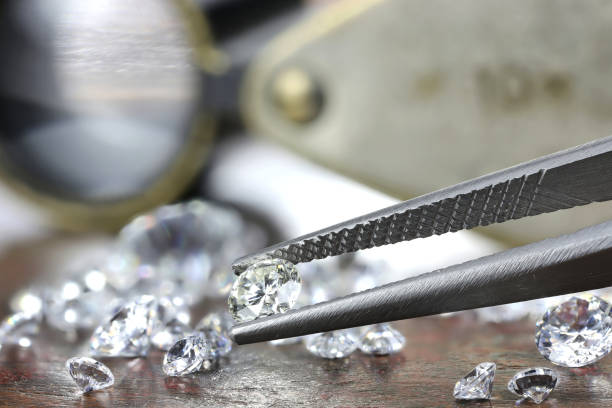 istock brilliant cut diamond held by tweezers 1627050015