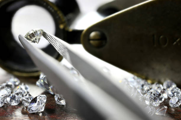 istock brilliant cut diamond held by tweezers 1627050622