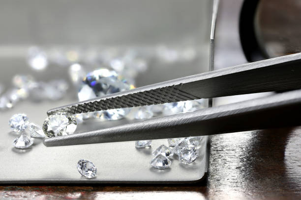 istock brilliant cut diamond held by tweezers 1627051196