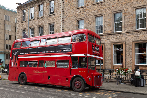 Edinburgh, Scotland - 19th July 2023: A vintage red Routemaster bus, formerly used by London Transport, waiting at its pick up place in St Andrew Square, Edinburgh to start its Afternoon Tea tour of the city. The Afternoon tea bus is operated by Red Bus Bistro, a Scottish company headquartered in Glasgow.