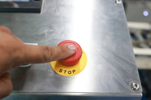 Stop the Red Button and the Hand of the Worker About to Press it. emergency stop button.  stop button for manual pressing.