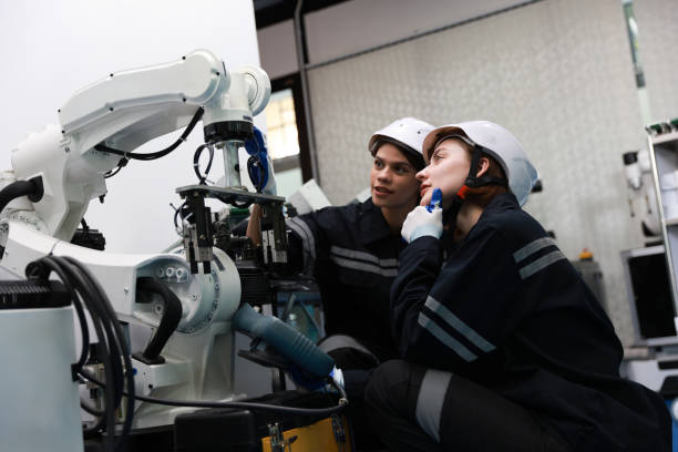 istock Female mechatronic  engineers team help together service industrial robots at laboratory testing in the factory 1627062831