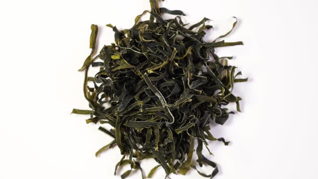 Pile of Dried seaweed wakame. Convenient semi-finished products, processed food. Japanese kelp or sea cabbage. Healthy algae snacks. 4K Video, Rotating