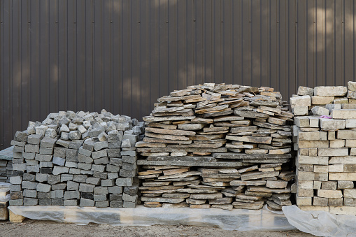 Stacks of different interlocking paving stones for installing driveway landscaping
