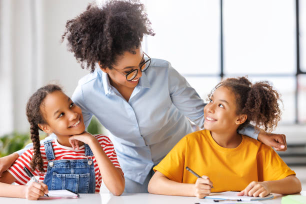 istock African american teacher smiling and helps students during lesson in bright classroom 1627102214