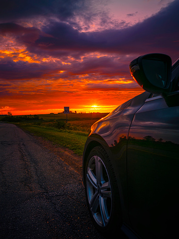 Sunrise Roadside Landscape on the TranceCanada Highway of Route 2 at Kensington in Prince Edward Island, Canada, dramatic cloudscape over the horizon with a partial view of parked car