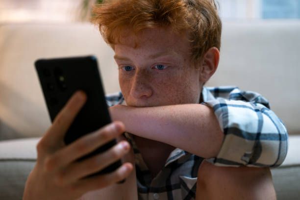 istock Sad boy with smart phone 1627122070