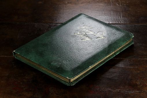 closed green diary with golden inscription on desktop