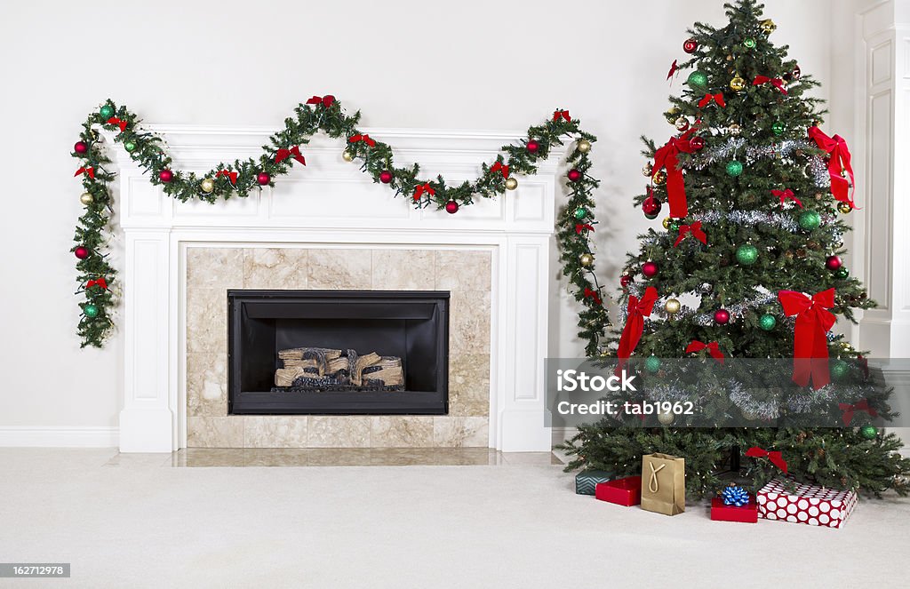 Gas Insert Fireplace in Use during Holidays Natural Gas Fireplace with fully decorated Christmas tree in living room of home during holidays Christmas Stock Photo