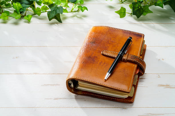 istock Ring bound planner and pen on wooden table 1627136096