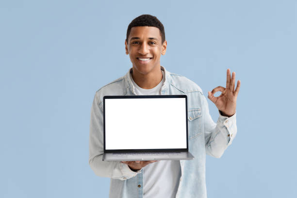 istock Happy man holding open laptop with blank screen isolated blue background smiling copy space 1627136124
