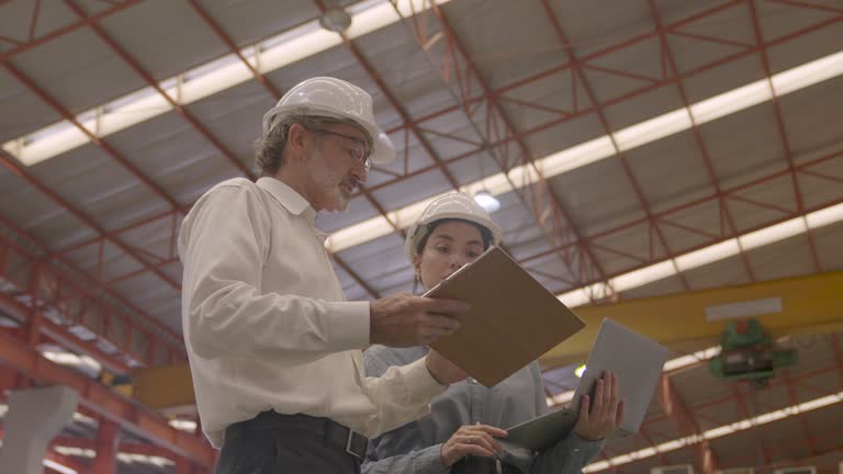 Male and female engineers in factory.