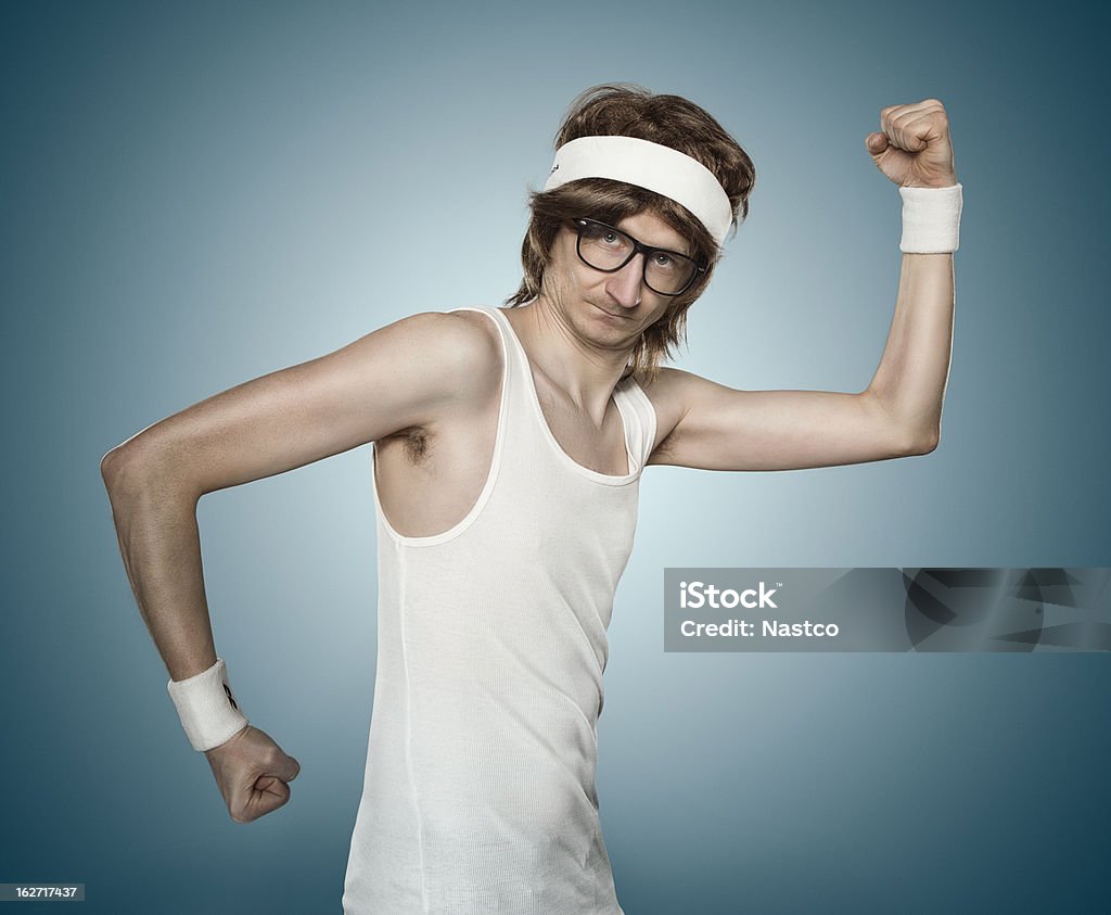 Funny retro sports nerd Funny retro sports nerd flexing his muscle over blue background Humor Stock Photo
