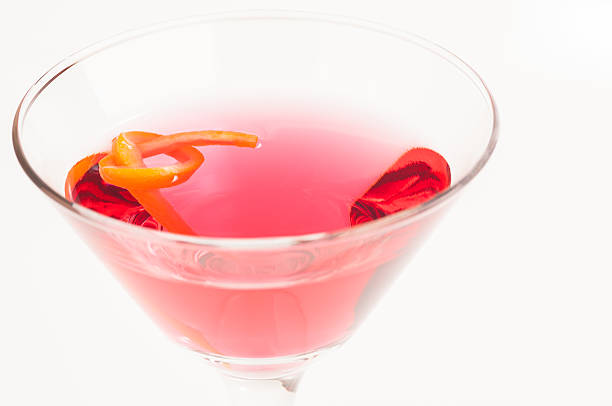 Pink Martini Cocktail made from Gin, Vermouth and a dash of Red Curacao garnished with orange twist. Very shallow depth of field with selective focus on the orange twist.
