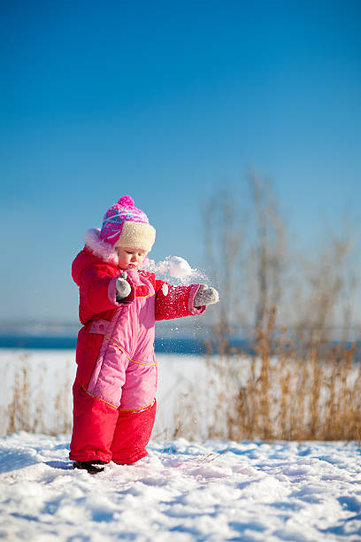 child throwing snow in winter stock photo