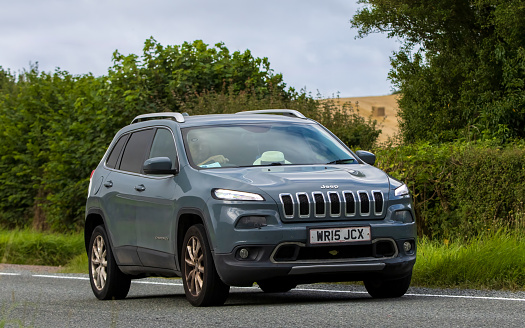 Woburn, Beds, UK - Aug 19th 2023: 2015 Jeep Cherokee  car travelling on an English country road.