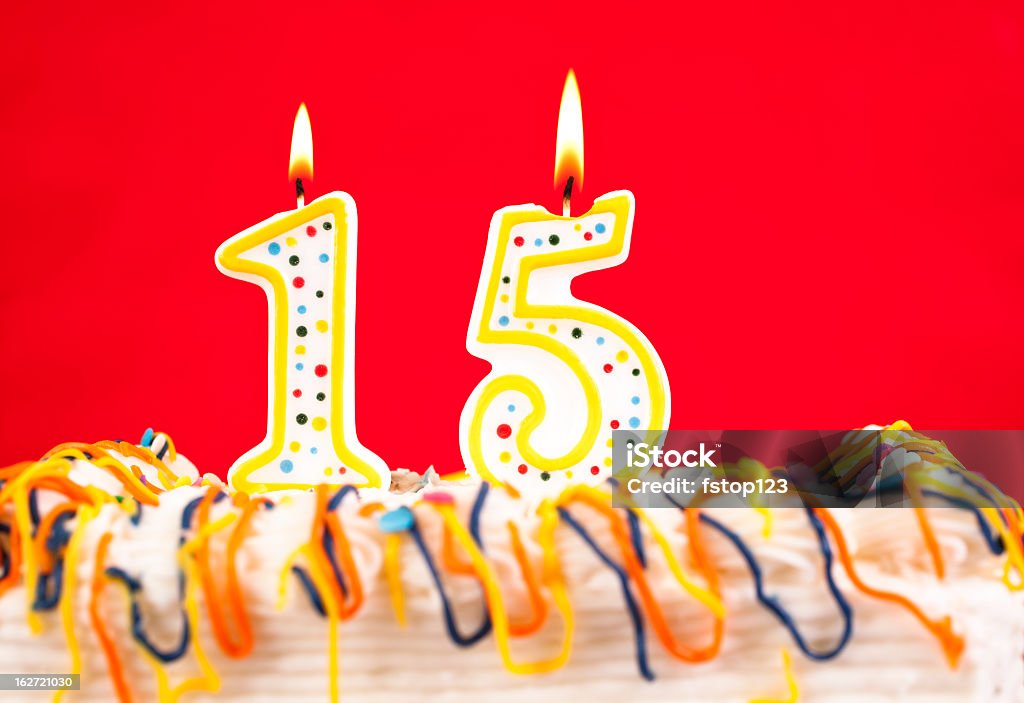 Decorated birthday cake with number 15 burning candles. Red background. Decorated cake  with number15 burning  candles.  Red background    Number 15 Stock Photo