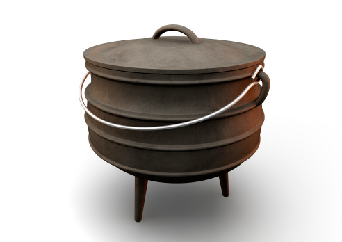 A regular cast iron south african potjie pot with a steel handle and a lid on an isolated background