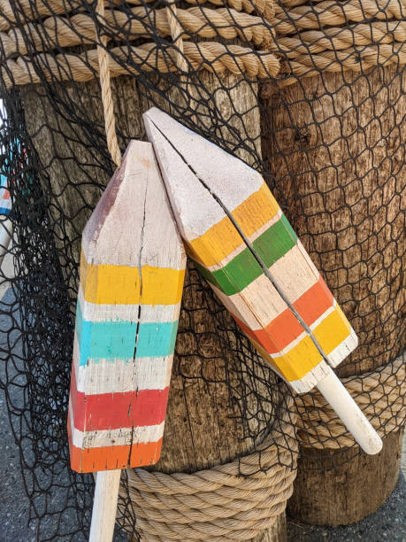 Colourful Nautical Buoy Decoration On Netted Logs Wrapped in Rope