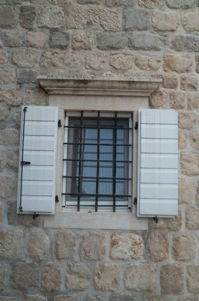 istock Traditional white wooden open window shutters on stone home 1627269267