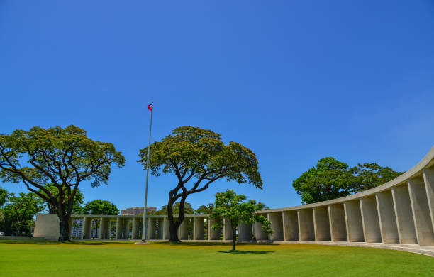 Manila American Cemetery and Memorial Manila, Philippines - Apr 13, 2017. Manila American Cemetery headstones with memorial building behind. Cemetery is located in Fort Bonifacio, in Taguig City, Manila. taguig stock pictures, royalty-free photos & images