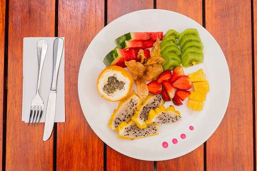 Healthy fruit breakfast on the hotel table based on strawberries, pineapple, dragon fruit, granadilla