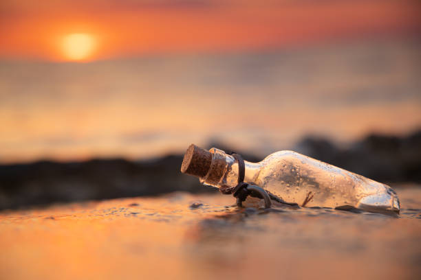 istock Message in the bottle against the Sun setting down 1627309070
