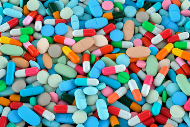 The pile of capsule drug in the container background stock photo