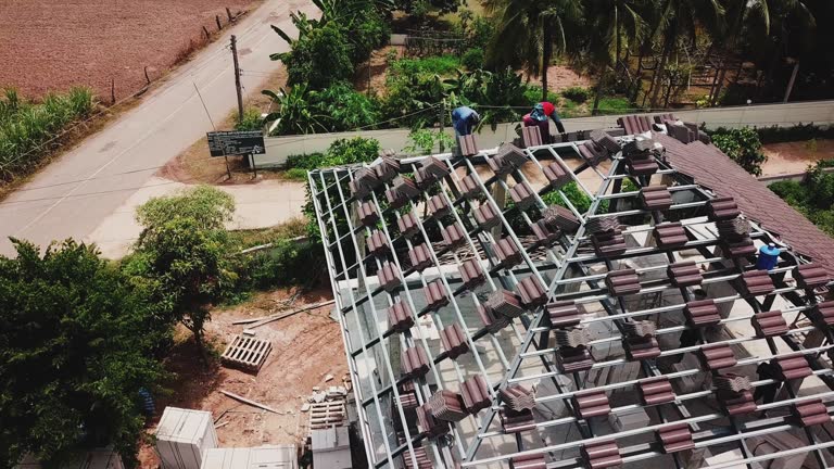 Aerial drone shot of roofers work on the roof.