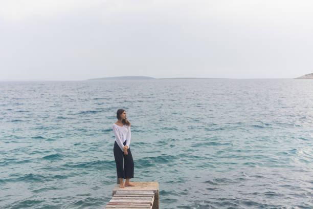 istock Young woman on a dock over the sea 1627322074