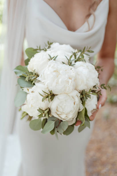 istock Bride holds bouquet of white flowers 1627330338
