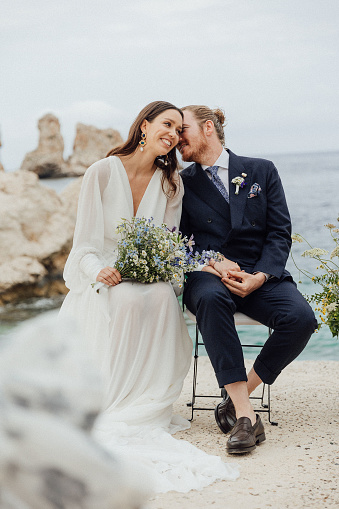 Senior Couple Getting Married In Beach Ceremony Looking At Each Other Smiling