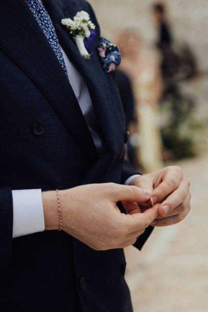 istock Groom holds wedding band outdoors 1627330962