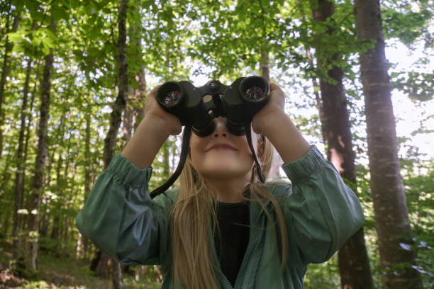istock Cute little girl exploring nature looking through binoculars. Child playing outdoors. Kids travel, adventure and bird watching concept. 1627337145