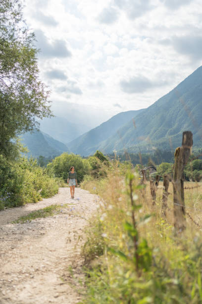 istock Young woman walks down country road 1627344344