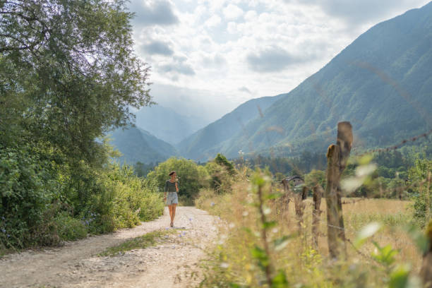 istock Young woman walks down country road 1627344345