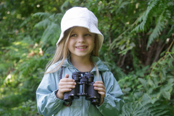 istock Cute little girl exploring nature looking through binoculars. Child playing outdoors. Kids travel, adventure and bird watching concept. 1627368788