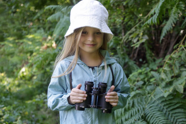 istock Cute little girl exploring nature looking through binoculars. Child playing outdoors. Kids travel, adventure and bird watching concept. 1627368791