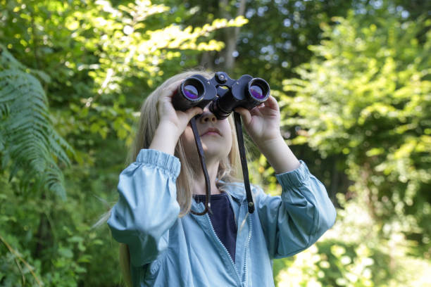 istock Cute little girl exploring nature looking through binoculars. Child playing outdoors. Kids travel, adventure and bird watching concept. 1627377555