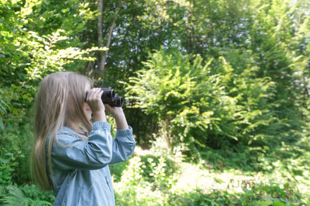 istock Cute little girl exploring nature looking through binoculars. Child playing outdoors. Kids travel, adventure and bird watching concept. 1627384555