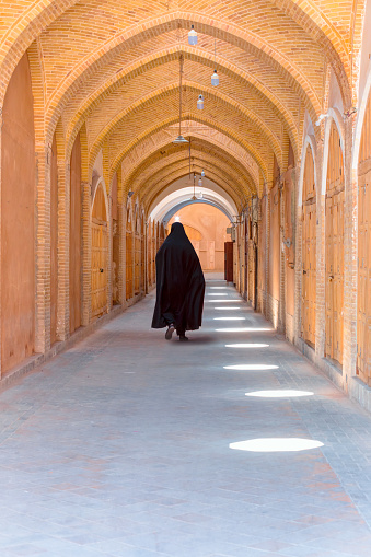 Iranian  woman walks in a completely close grand bazaar - Shiraz, iran