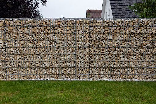 White gabion stones and a piece of lawn in the garden
