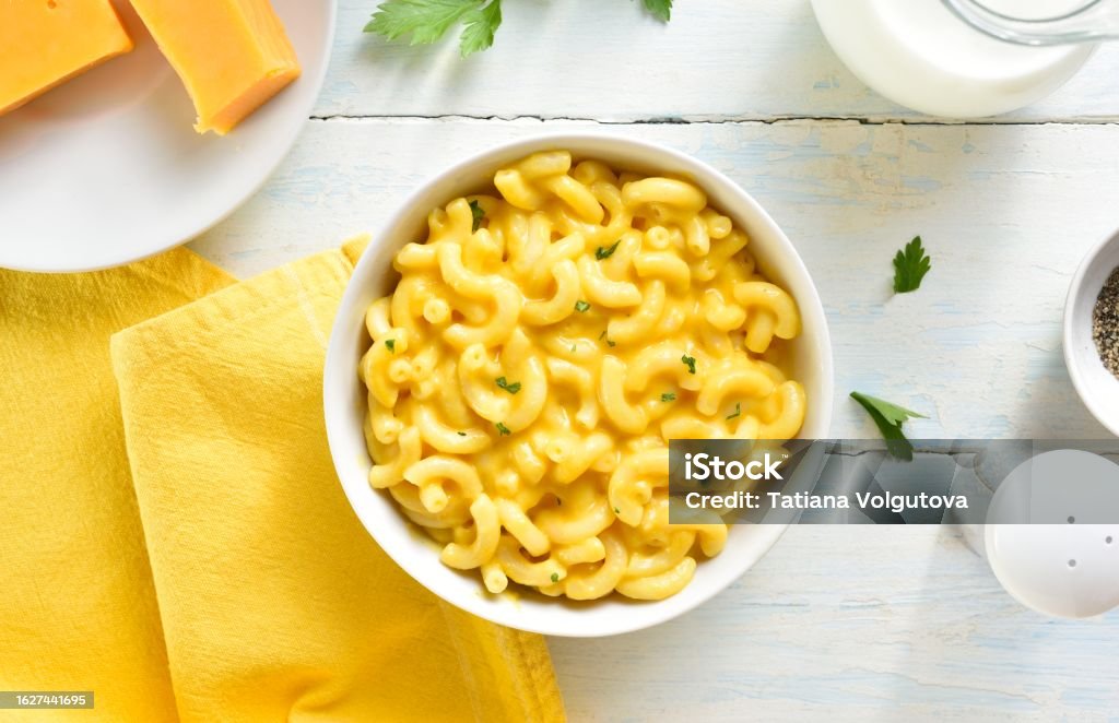 Macaroni and cheese Macaroni and cheese in bowl over wooden background. Top view, flat lay Macaroni Stock Photo