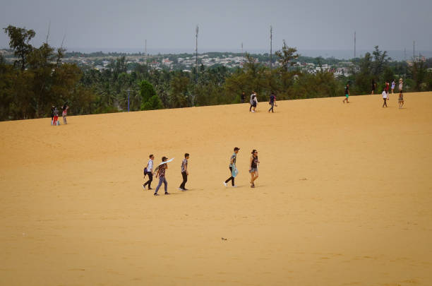 Mui Ne, Vietnam - Jun 3, 2017. Tourists walking on the sand dunes in Mui Ne, Vietnam. Sand Dunes just outside of Mui Ne are one of Vietnam charming geological oddities.