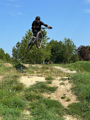 jumping with the mountain bike under blue sky.