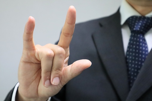 Photo of a businessman doing a sign language 