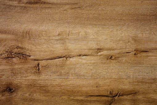 Rough natural wooden board. Scratches, cracks and knots are strongly expressed. A wood grain pattern running horizontally across the image.