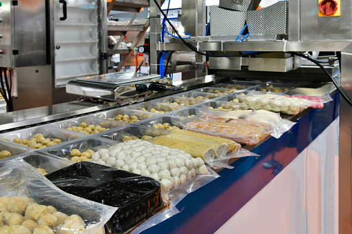 Candy factory. Sweets spilling from conveyor. Bunch of wrapped candies falling from conveyor on packing containers in confectionery factory.